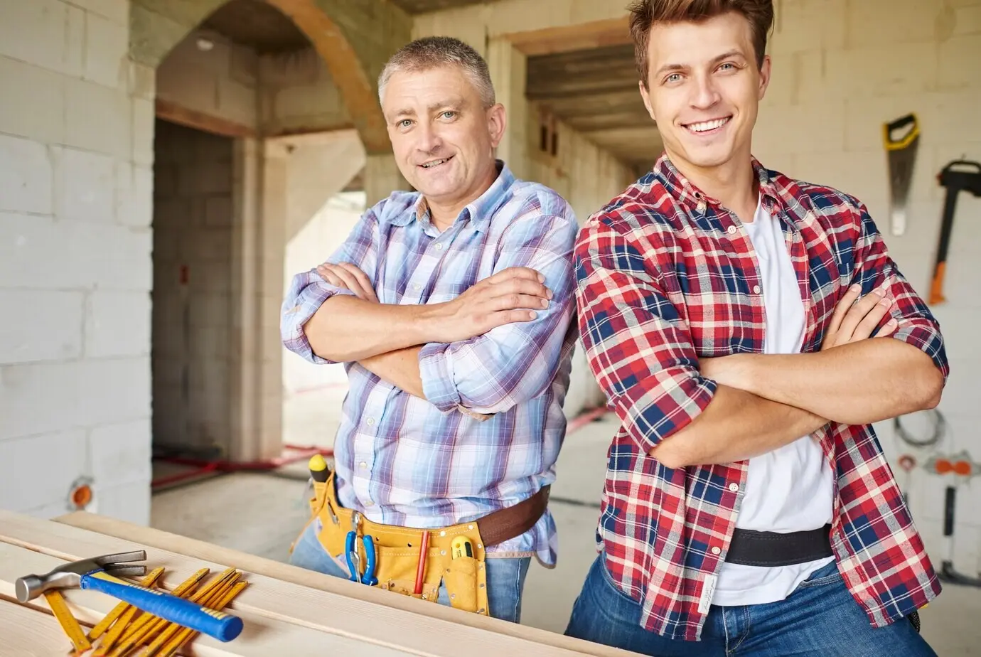 Close-up of an experienced carpenter and his younger employee.
